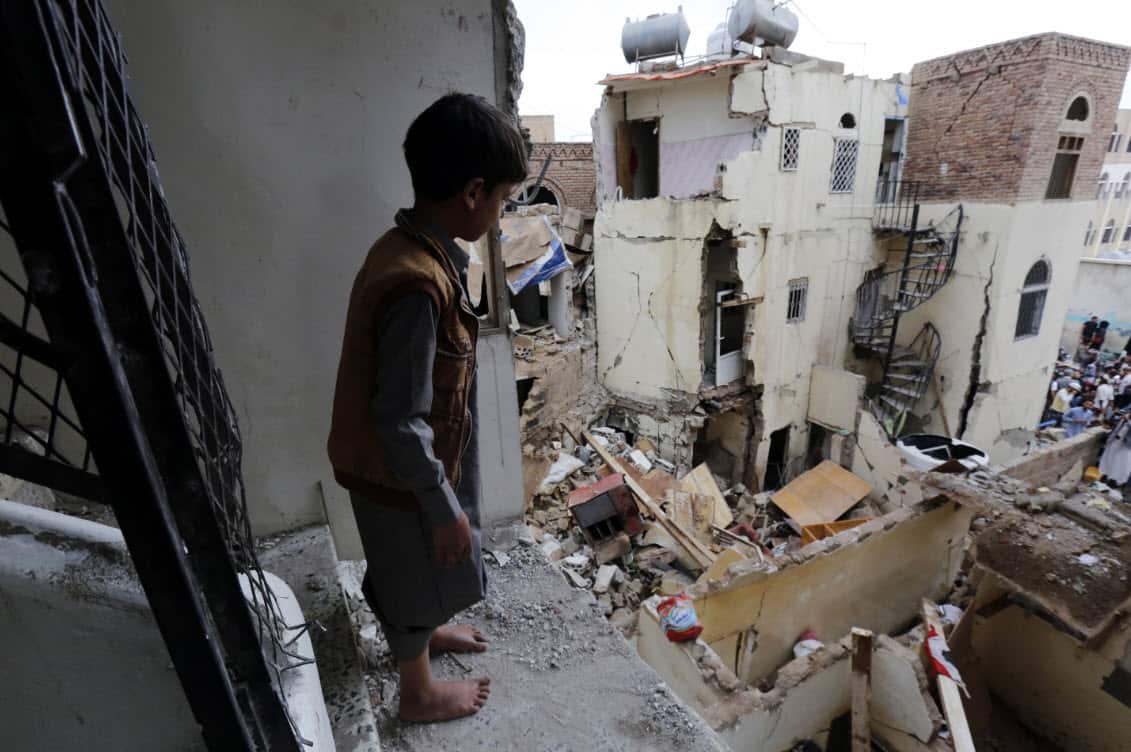 File image of a boy looking at destroyed houses at a neighborhood, a day after being targeted by a Saudi-led airstrike, in Sanaa.
