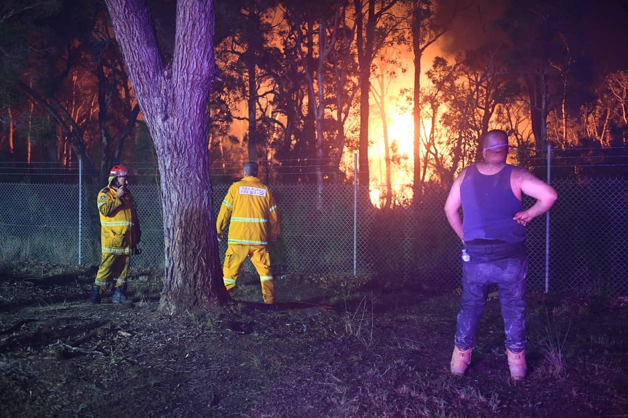 Local residents and firefighters watch flames close to homes in Corryton Court, Wattle Grove.