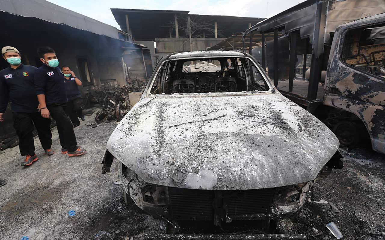 Rescuers inspect burnt out cars at the site of an explosion at a firecracker factory in Tangerang.