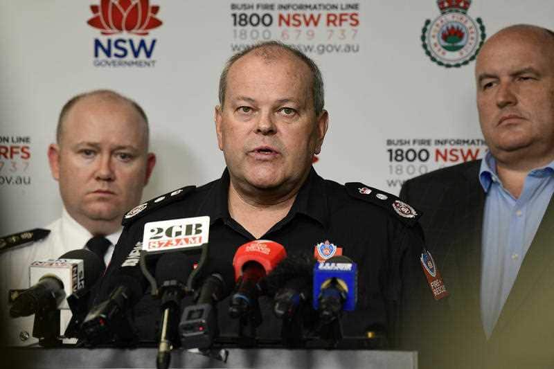 Fire and Rescue NSW Commissioner Paul Baxter (centre) speaks to the media, detailing the latest fire updates. 