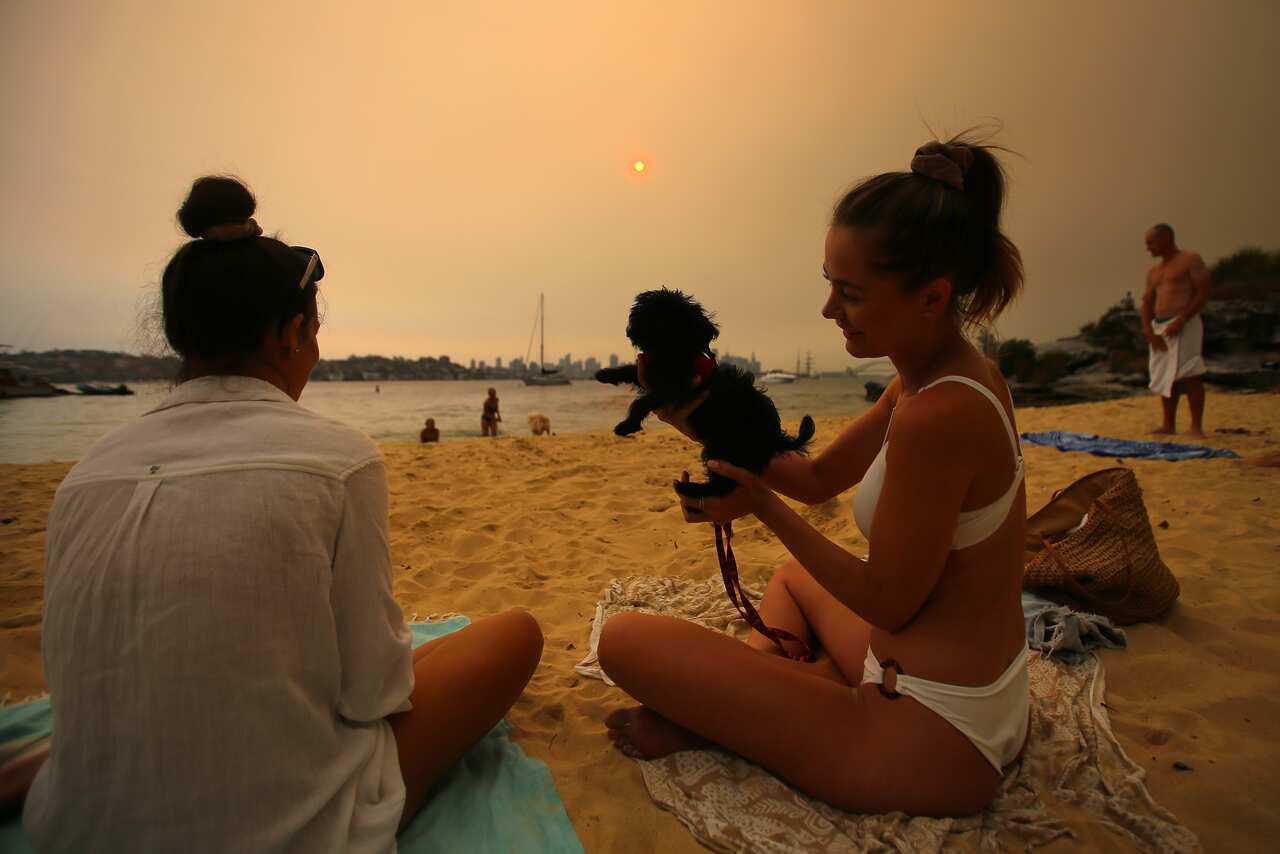 Beachgoers on Milk Beach as smoke haze from bushfires in New South Wales blankets Sydney.