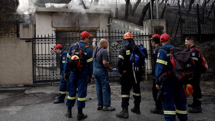 Firefigthers look for survivors by searching house by house in the area of Neo Voutza, northeast Attica, Greece.