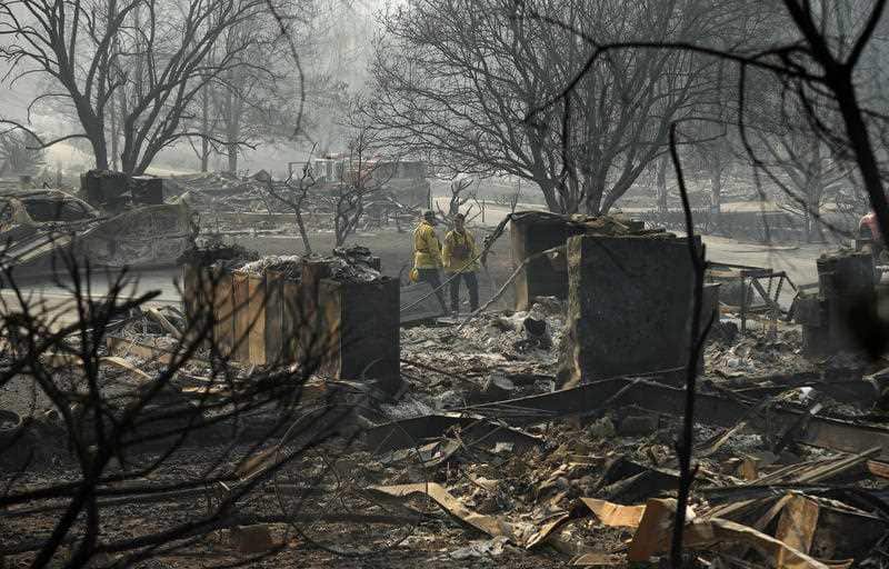 Rescue workers among the burnt out remains left in the wake of the fire.