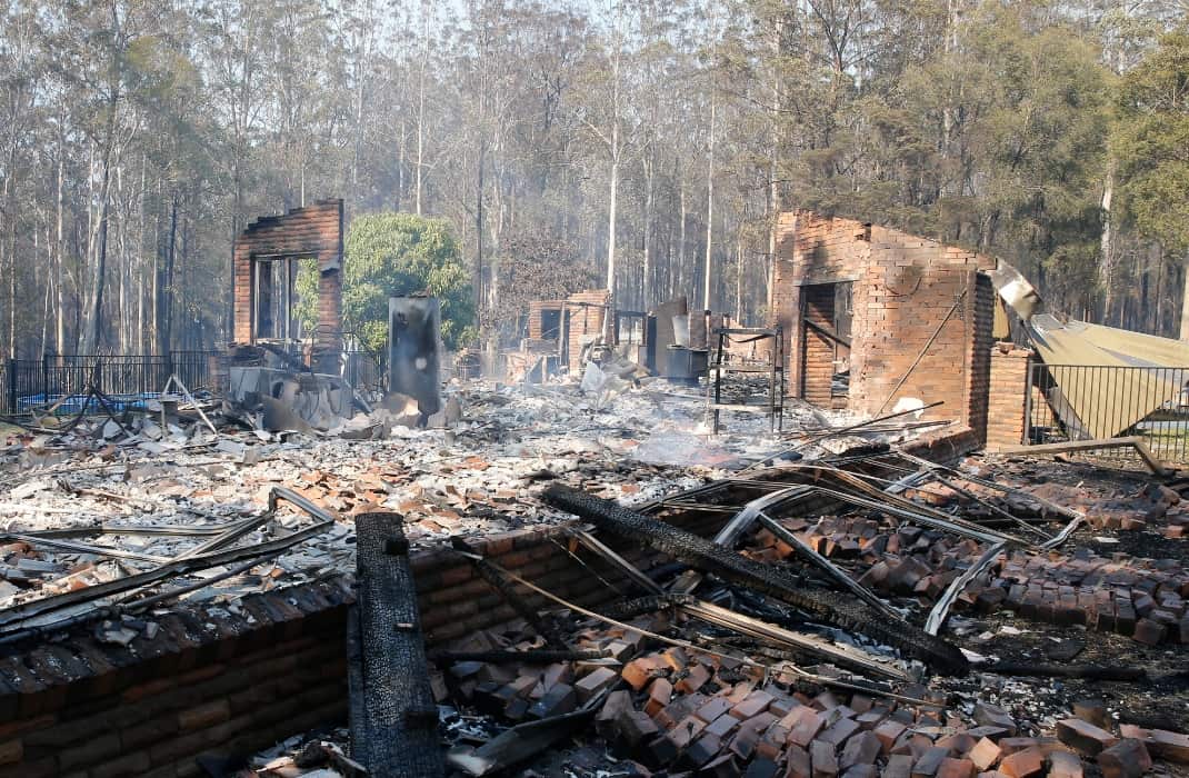 The remains of the residence at Four Paws boarding kennels smoulders along the Pacific Highway south of Taree, Saturday, November 9, 2019.