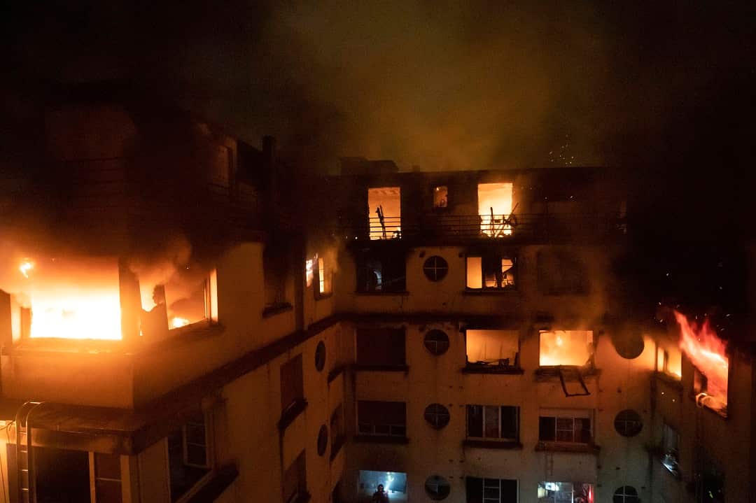Fire rages through the top floors of an apartment building in Paris, France. 