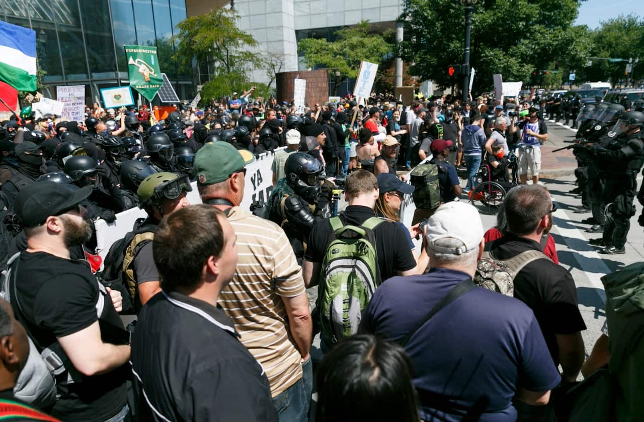 Police form a line during a rally in Portland, Ore., Saturday, Aug. 4, 2018.