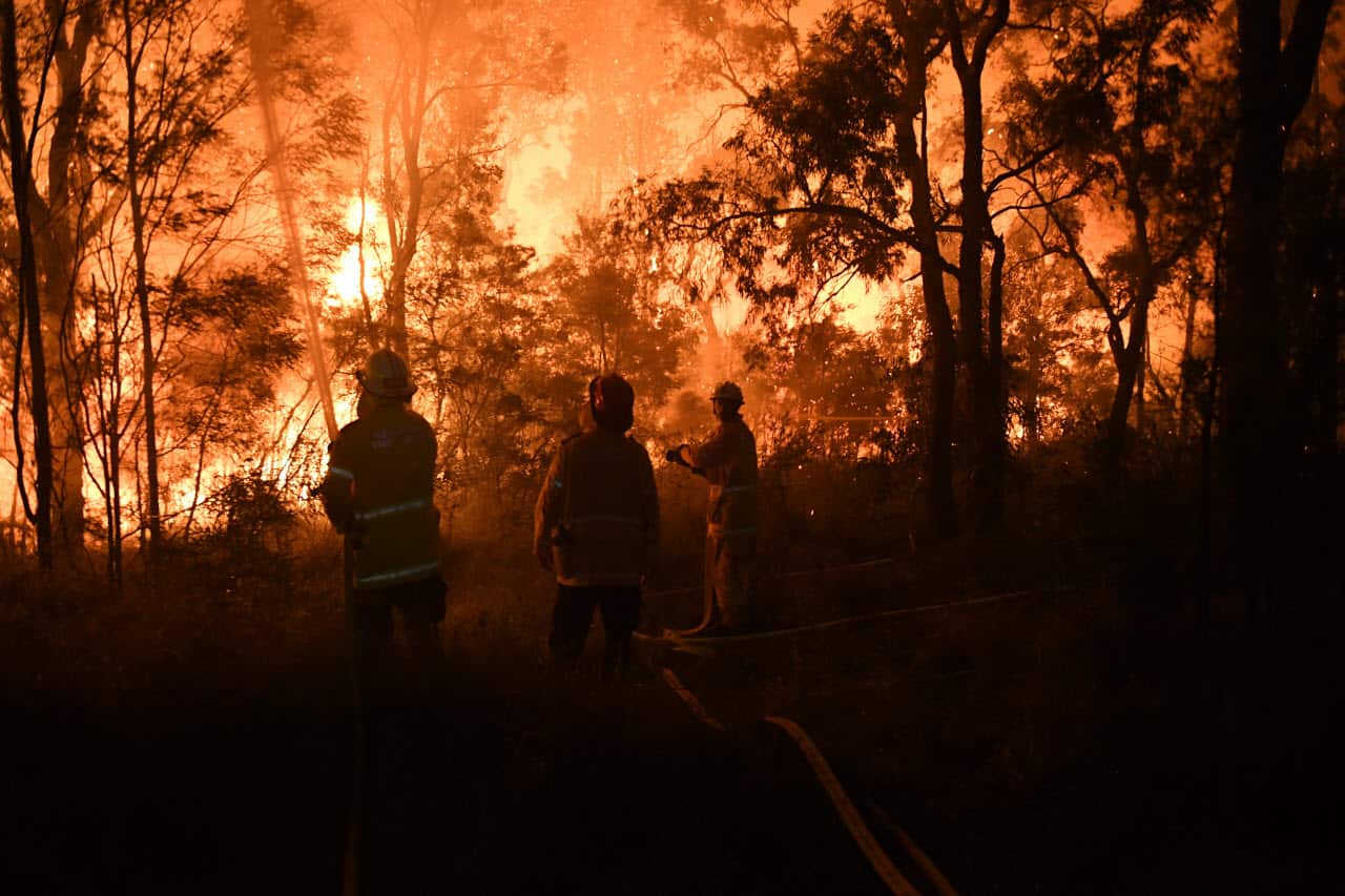 Firefighters fight flames close to homes in Corryton Court, Wattle Grove in Sydney, Saturday, April 14, 2018. 