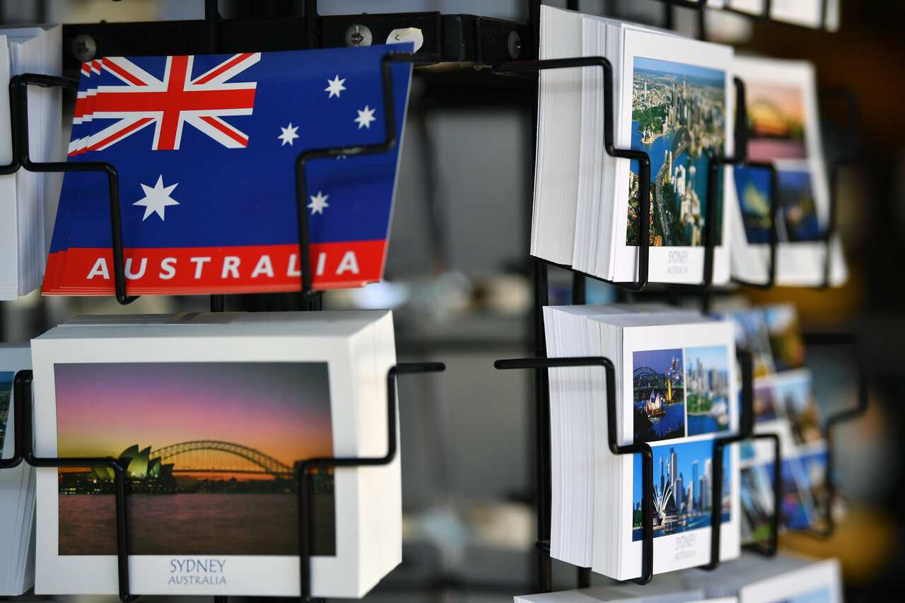 Postcard souvenirs on a rack at a retail store in Sydney. Australia remains open for business, according to the government. 