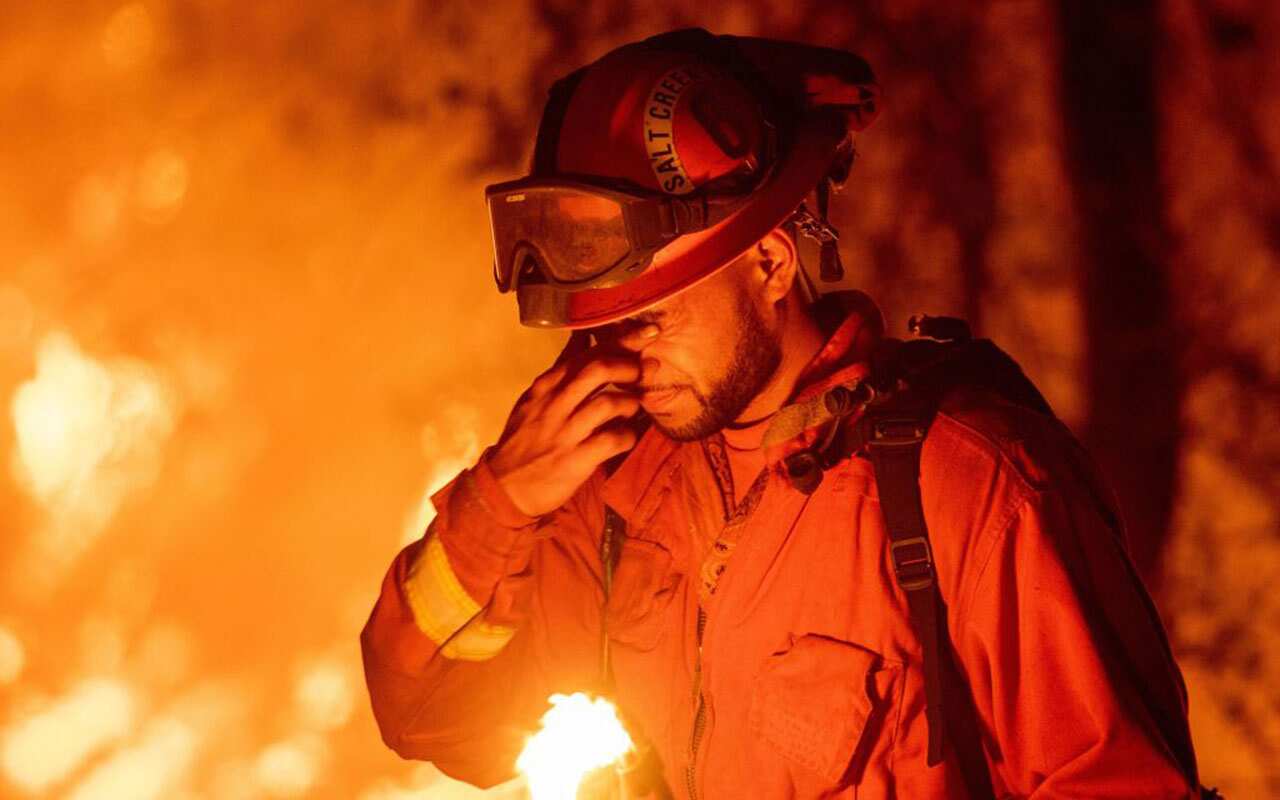 A firefighter pauses while battling fires near Redding, California.