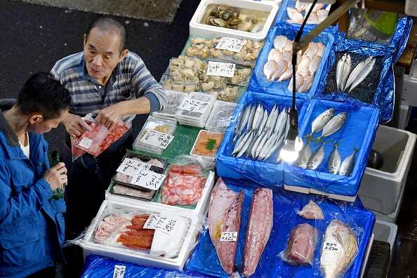 An intermediate wholesaler chats with a customer at his fish store in Tsukiji fish market ahead of the relocation. 
