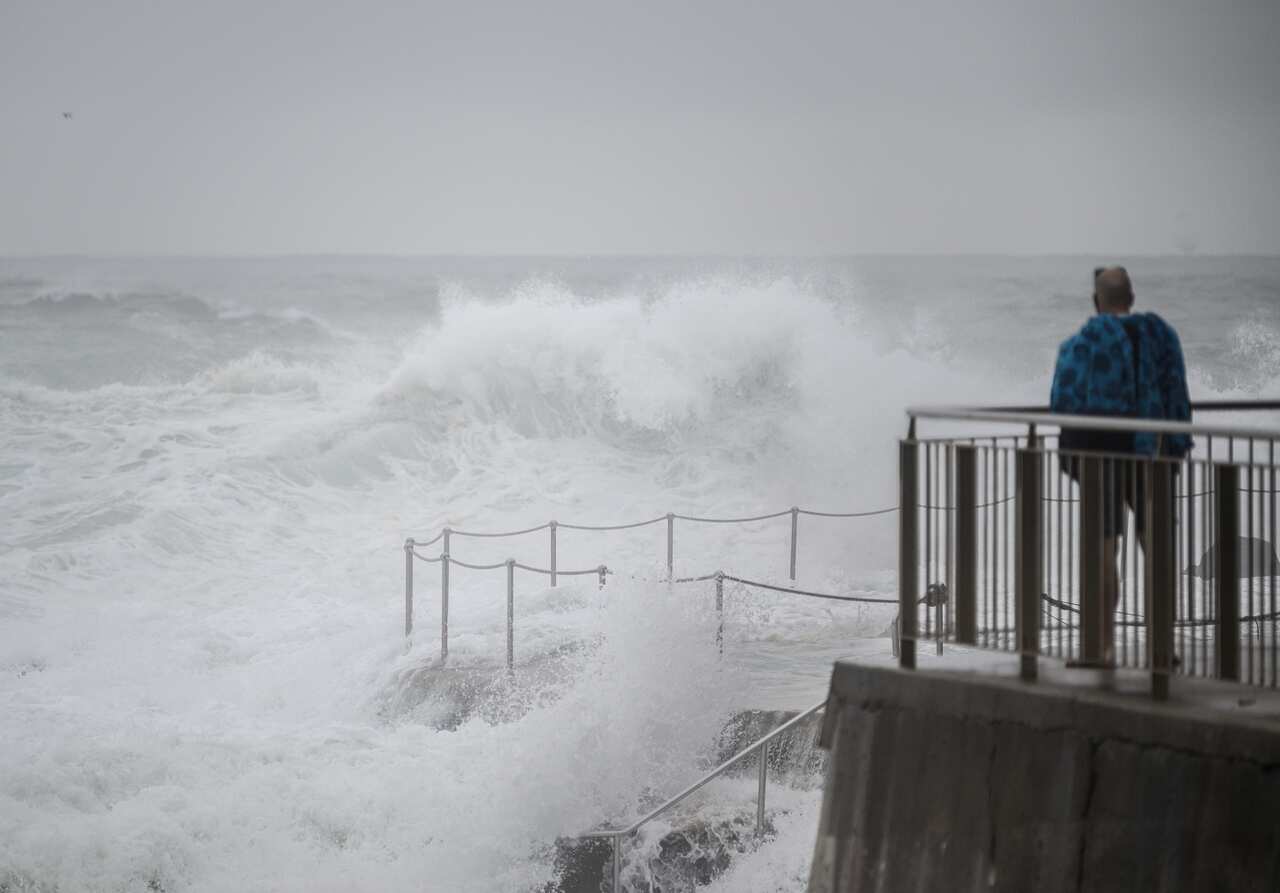 A person watching rough ocean conditions at Bronte Beach as wild weather stirs up dangerous conditions. 