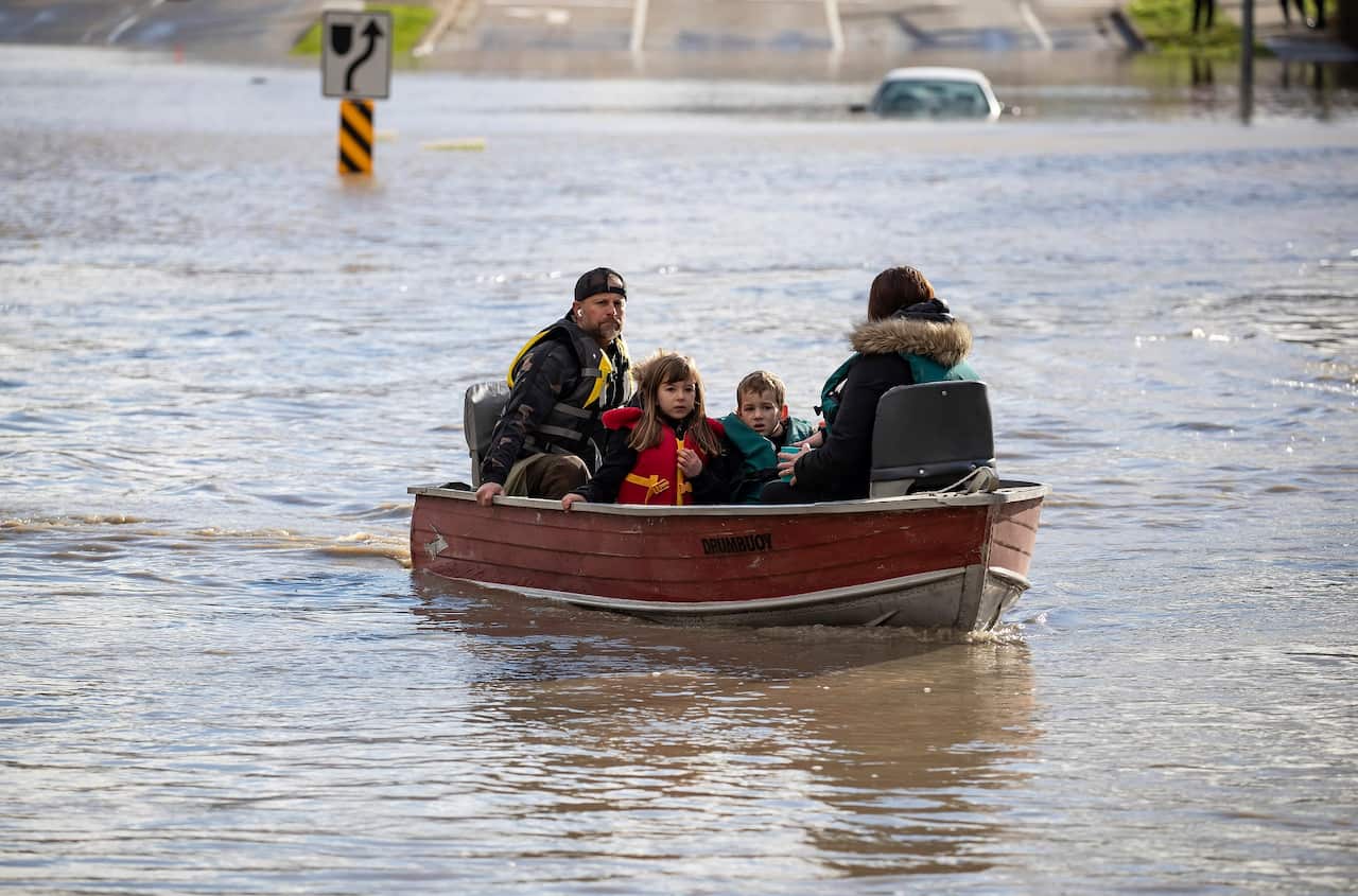 A woman and children who were stranded by high water due to flooding are rescued in British Columbia.