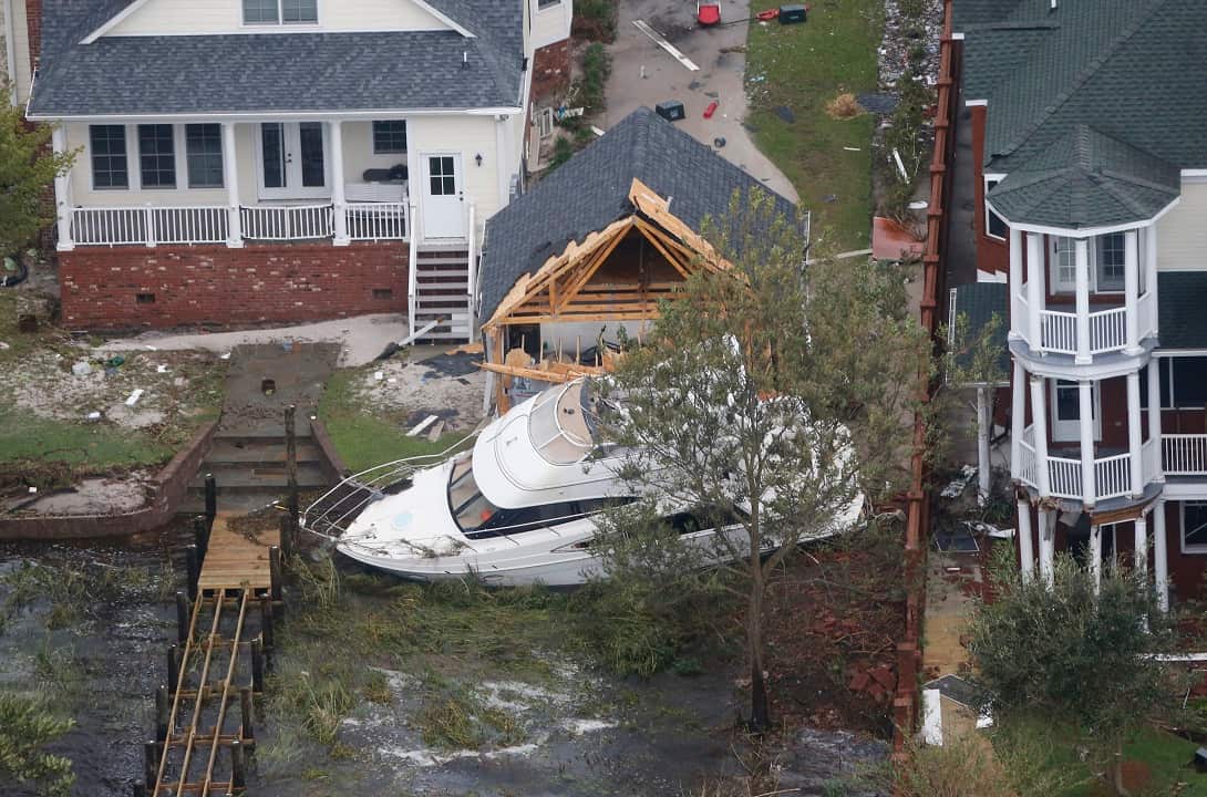A yacht sits on the Neuse river bank in between buildings after hurricane Florence passed through the area.