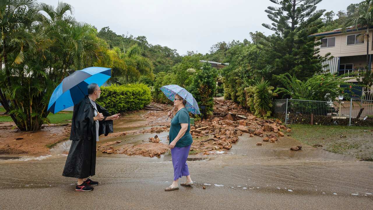 Residents Kerry and Josephine Guinea observe rocks blocking Muller Street in Wulguru, in Townsville on 1/2/19.