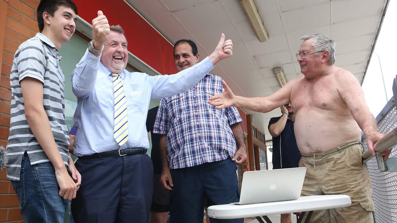 Former councilor Paul Tully (second left) reacts with other flood victims after listening to a live stream of the NSW Supreme Court.