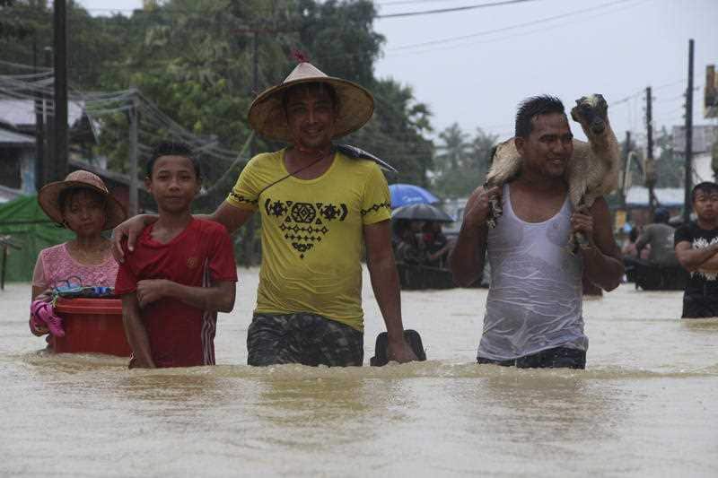 Residents wade through a flooded street in Bago, about 80 kilometers, northeast of Yangon.