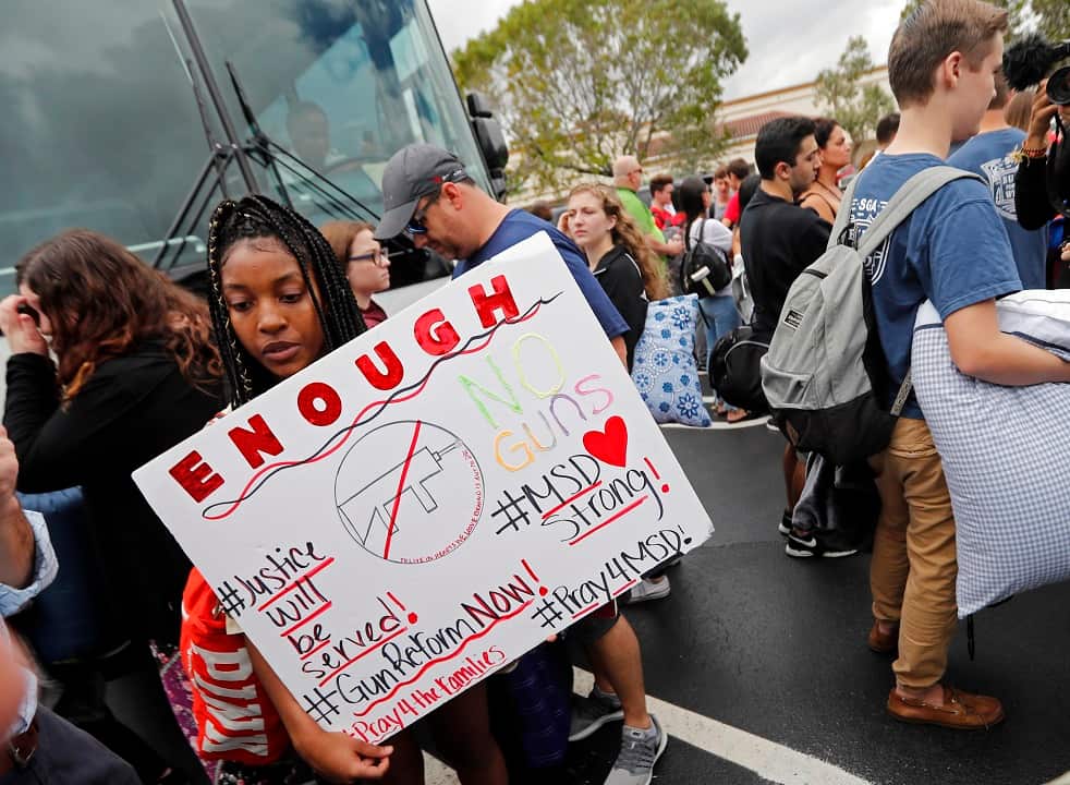 Tyra Hemans, 19, left, and Logan Locke, 17, right, student survivors from Marjory Stoneman Douglas High School wait to board buses in Parkland.