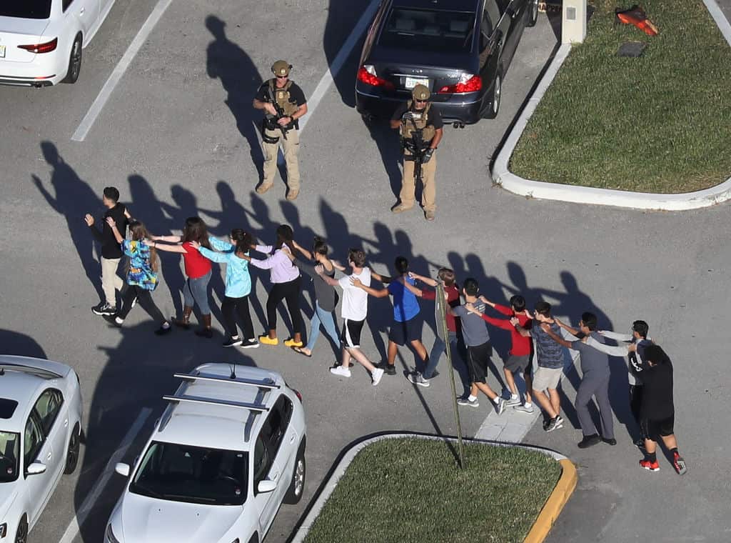 People are brought out of the Marjory Stoneman Douglas High School after a shooting at the Florida school.