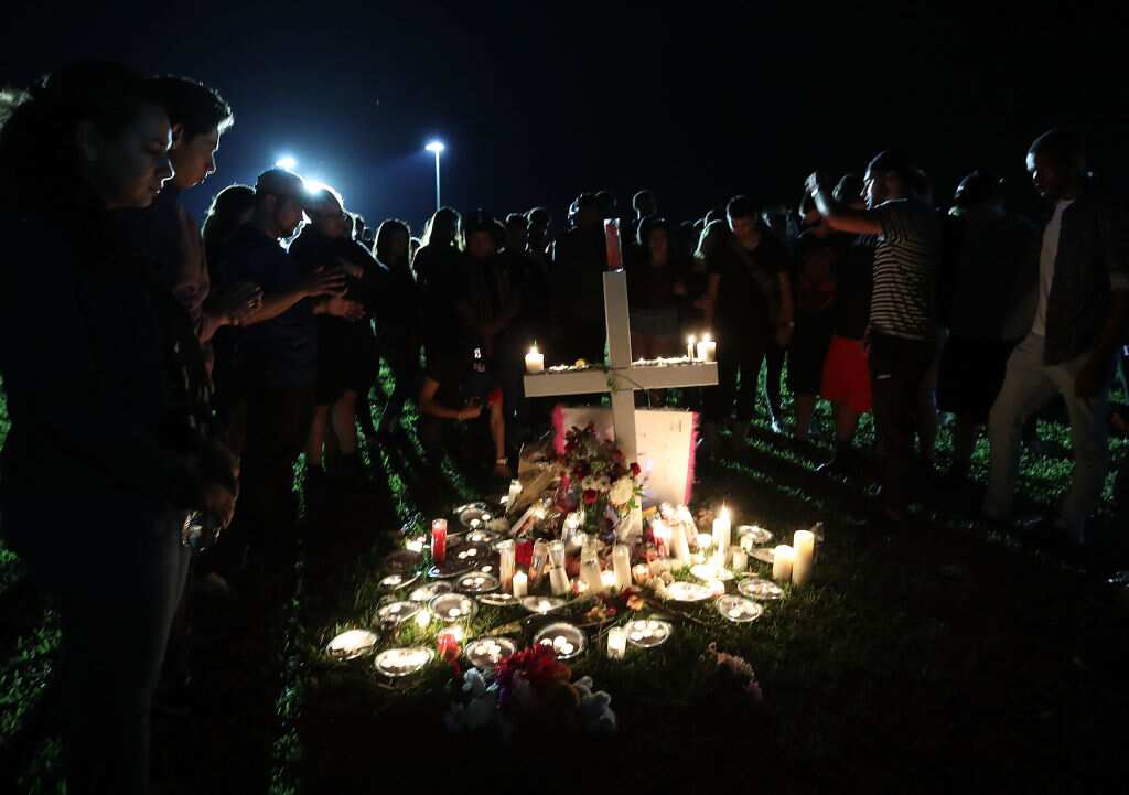 Students, friends, and family gather to pray during a candlelight vigil for victims of the mass shooting at Marjory Stoneman Douglas High School.