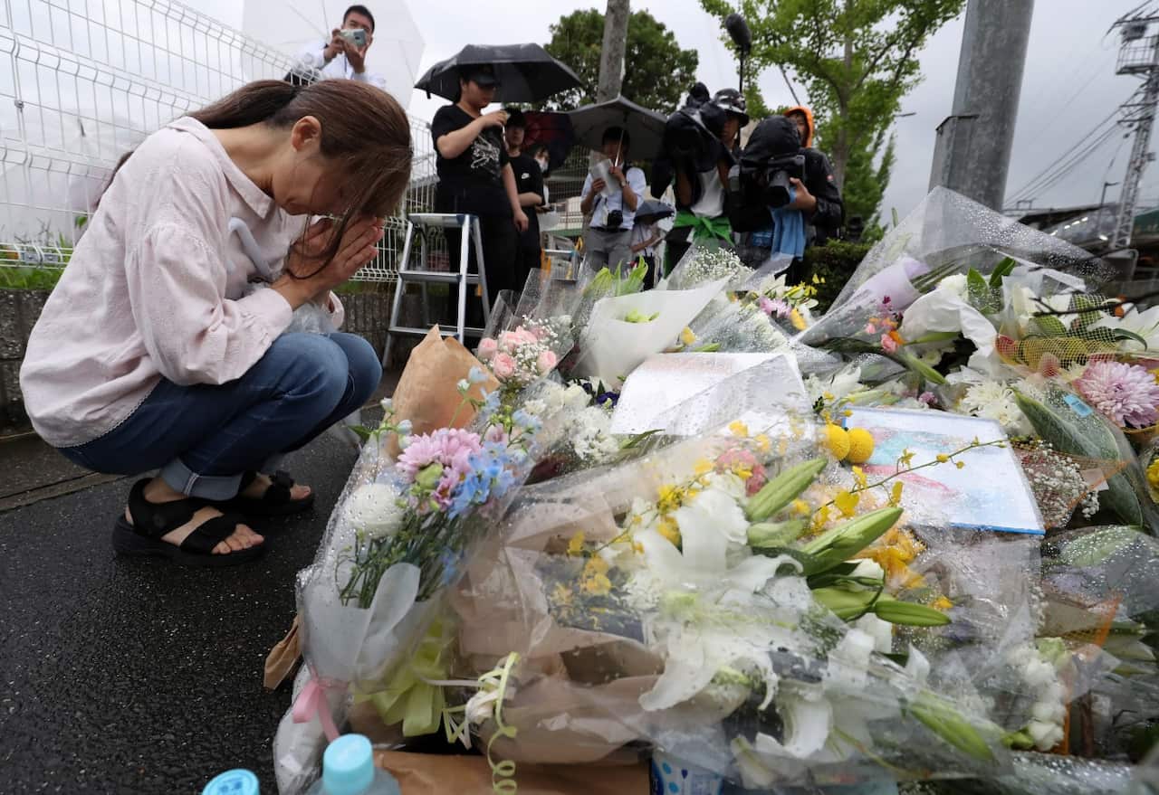 A woman prays for victims outside the Kyoto Animation building, in Kyoto, Japan, 19 July 2019