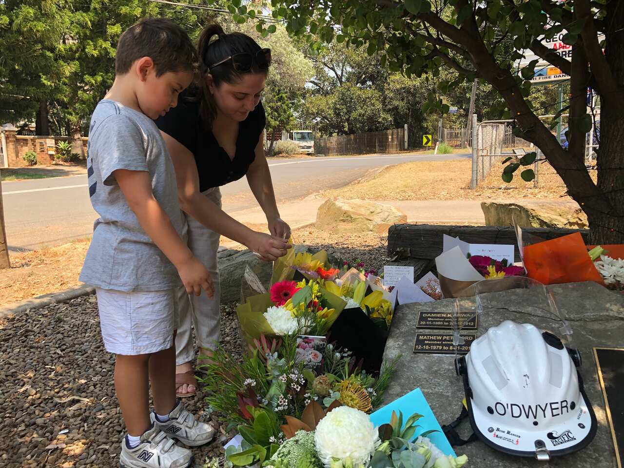 Dalia Matti and her son lay flowers outside the Horsley Park Rural Fire Brigade.