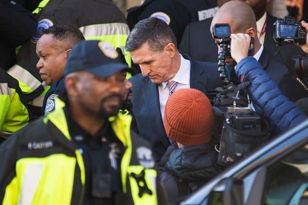 Michael Flynn, former national security adviser, leaves court after a federal judge delayed his sentencing.