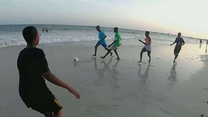 Some downtime on the beach, still with a ball at their feet. 