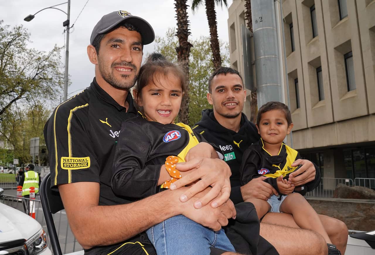 Marlion Pickett of the Tigers holds his daughter Shaniquae during the AFL Grand Final Parade. 