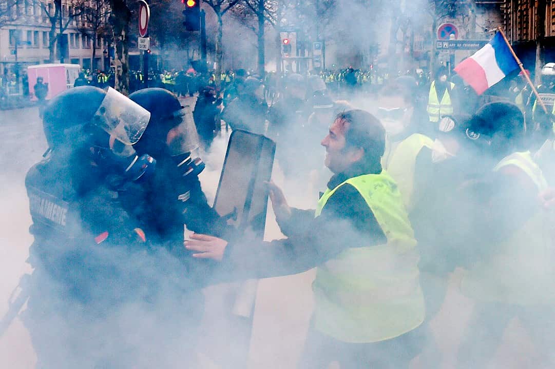 Demonstrators clash with riot police during a protest of Yellow vests (Gilets jaunes) against rising oil prices and living costs.