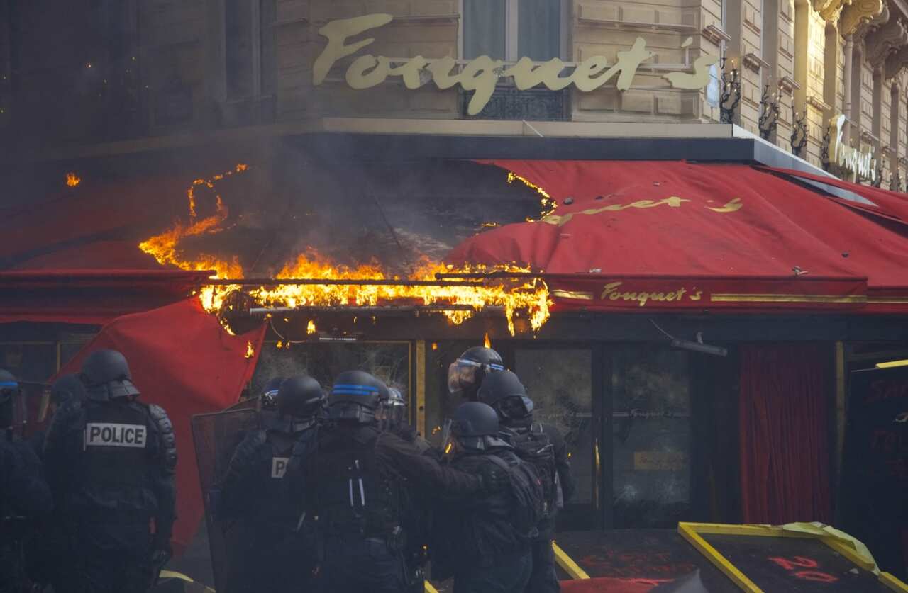 Restaurant "Le Fouquet's" set on fire during clashes with riot police forces on the Champs-Elysees during the 18th consecutive Saturday