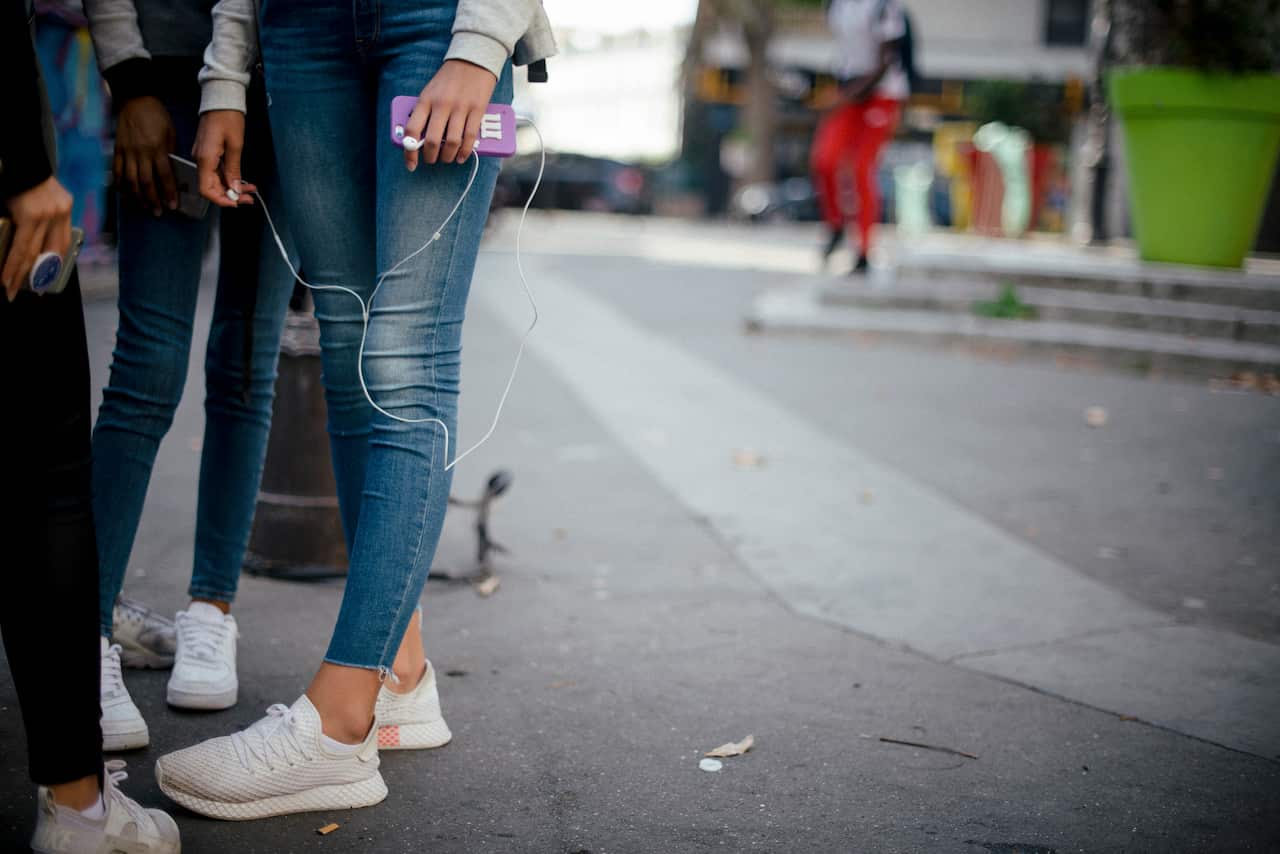 Teenagers use their phones after school in Paris.