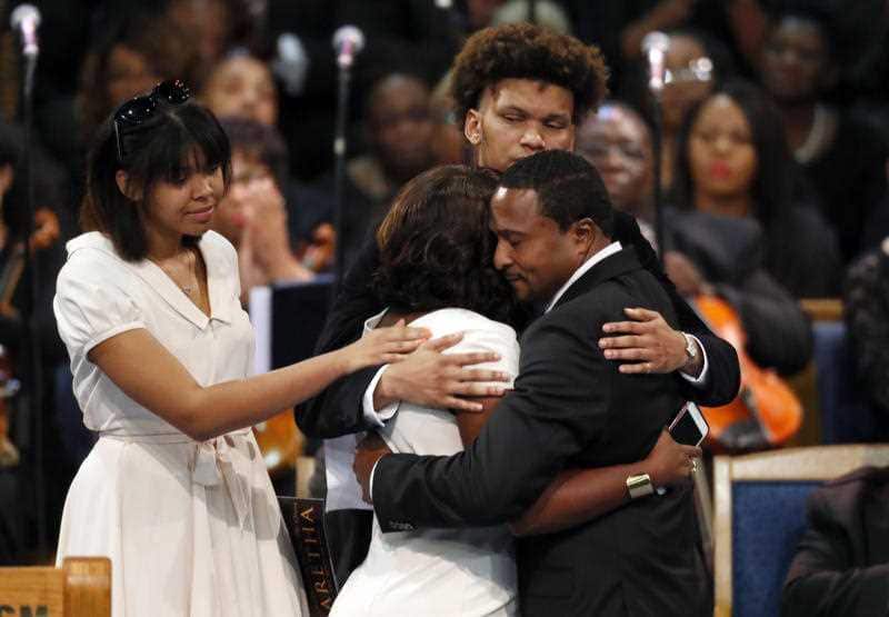 Cristal Franklin hugs Vaughn Franklin as Victorie Franklin, left, and Jordan Franklin look on during the funeral service for Aretha Franklin.