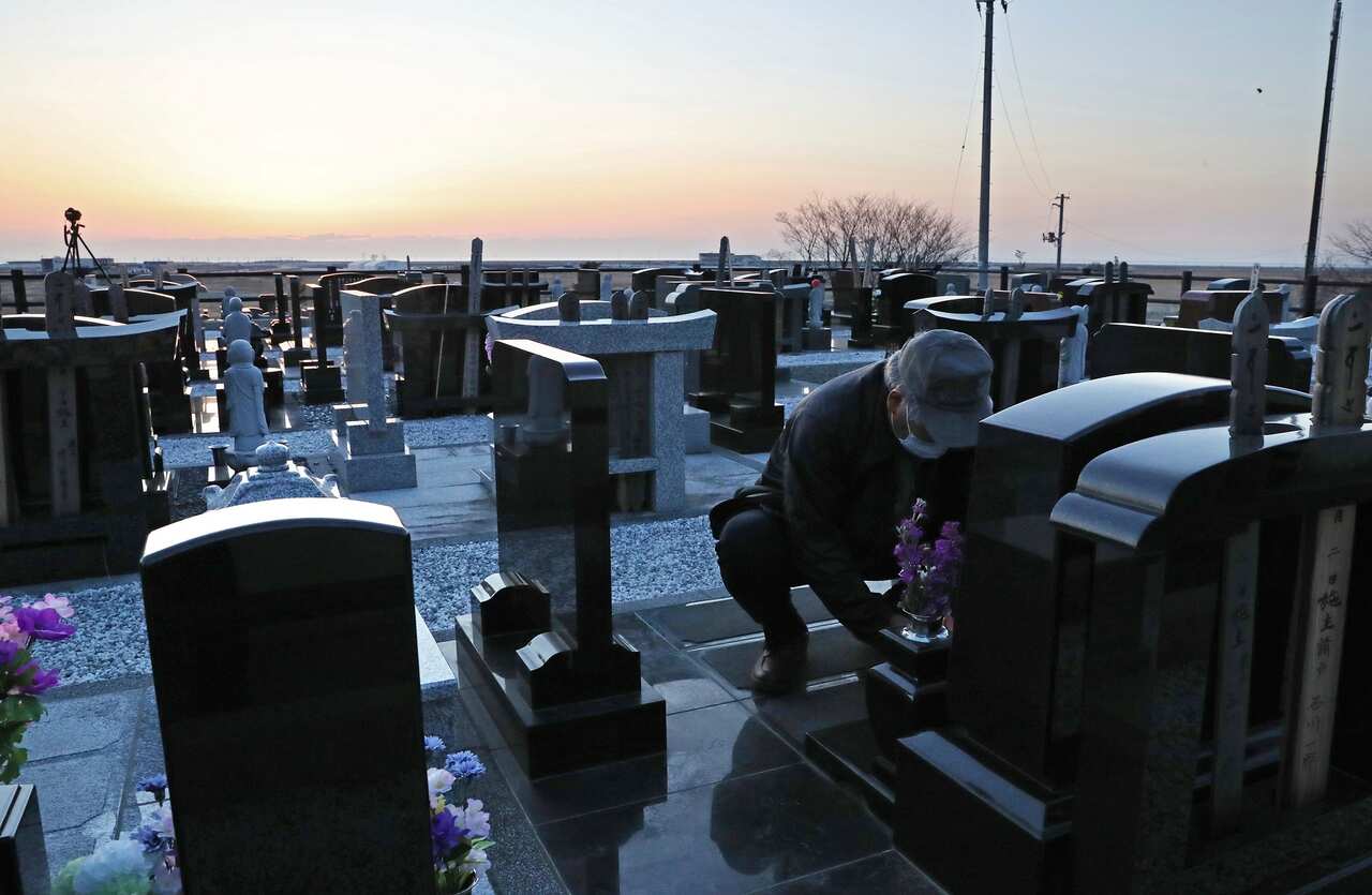 Tadamasa Ishikawa visits a graveyard to pray for his three friends who were killed during the 2011 Fukushima disaster. 