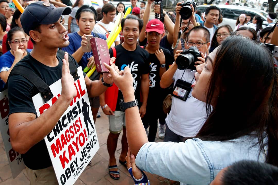 An LGBT member, right, and a Christian protester briefly debate as thousands participate in the Pride March.