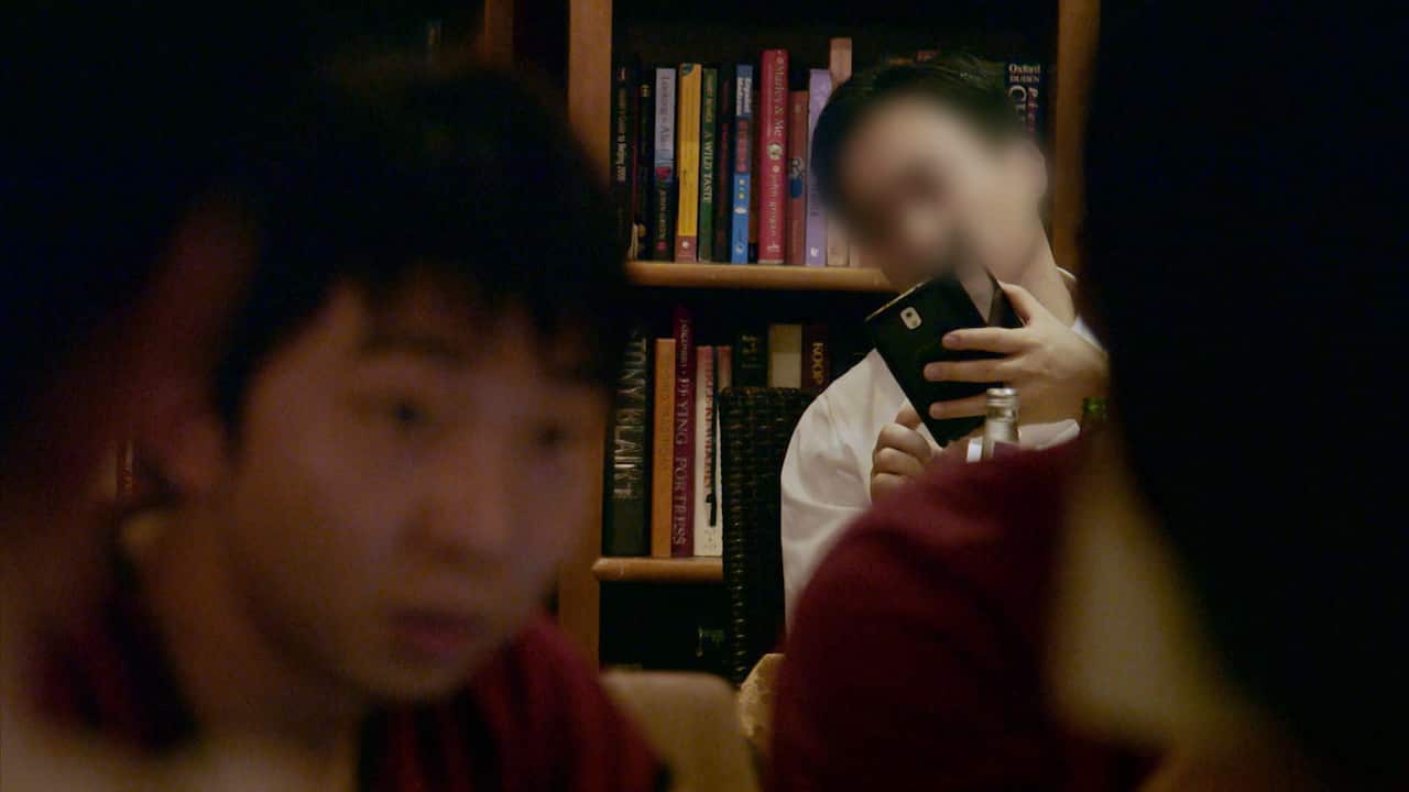 During a meeting in a cafe, the LGBT campaigners notice a man and later two women are taking photographs of them.