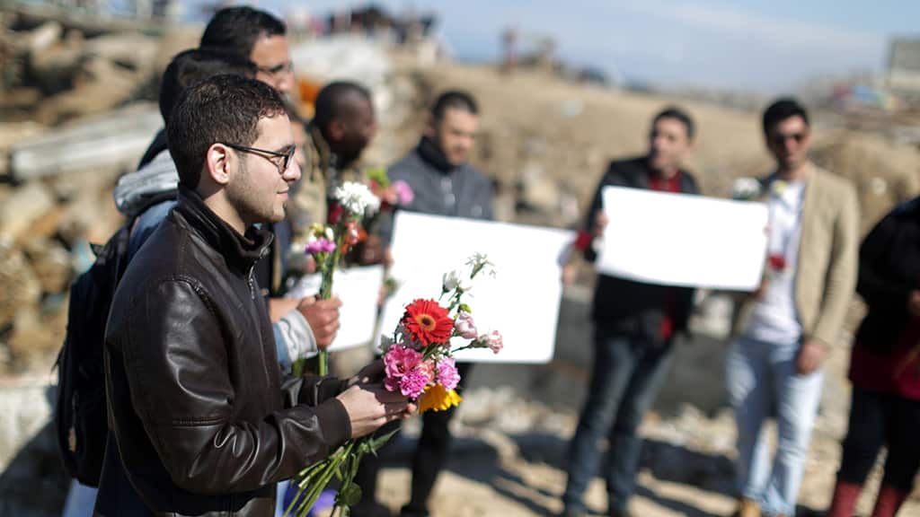 Palestinians carrying flowers hold a memorial at the sea of Gaza City, on February 14, 2015.