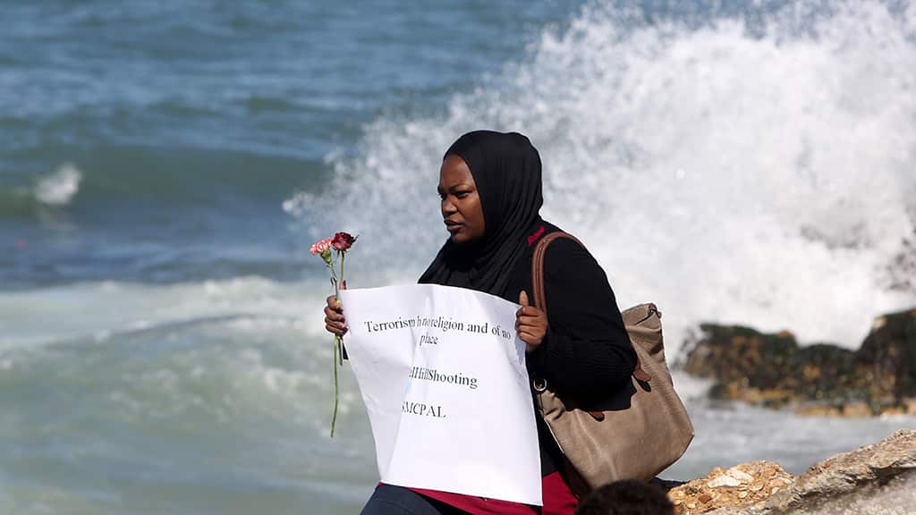 A Palestinian woman carrying flowers gathers at the sea of Gaza City, on February 14, 2015.