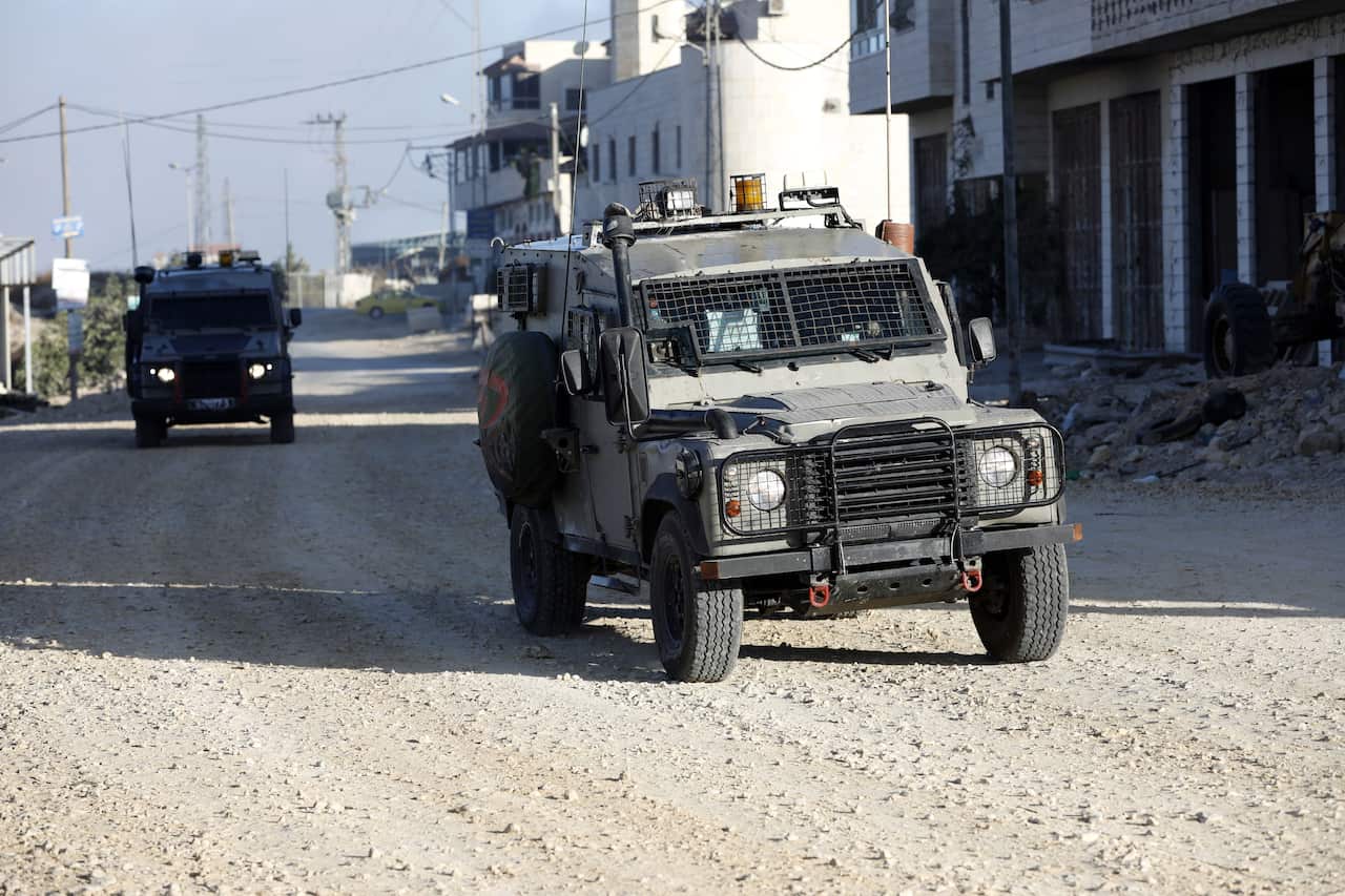 Israeli army vehicles at a street in the West Bank village of Beit Kahil. Israeli troops say they killed four Palestinians at the border.