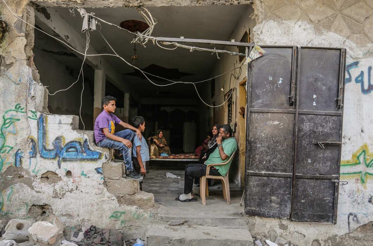 Palestinians sit among the rubble of their destroyed homes after a ceasefire in Gaza comes into effect.
