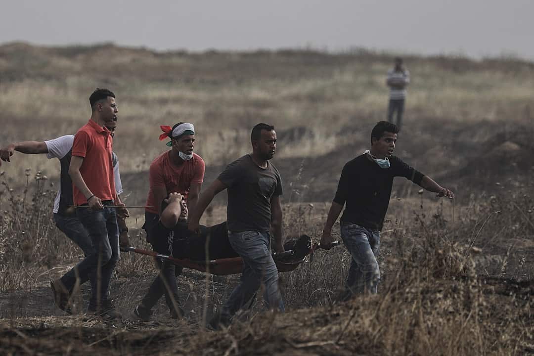 Palestinians carry a wounded protester during clashes after Friday protests near the border with Israel in the eastern of Gaza City.