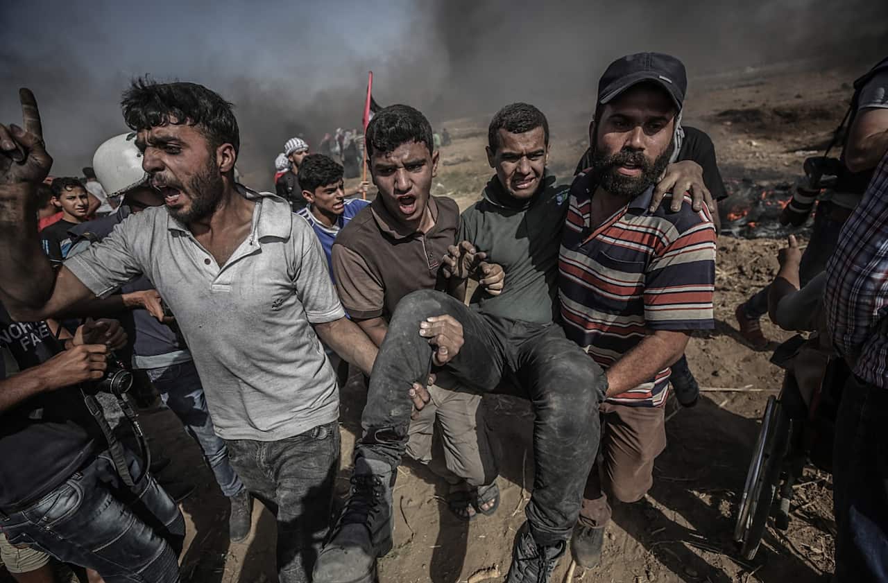 Palestinians protesters carry a wounded protester during the clhases after Friday protest near the border east Gaza City on, 08 June 2018.