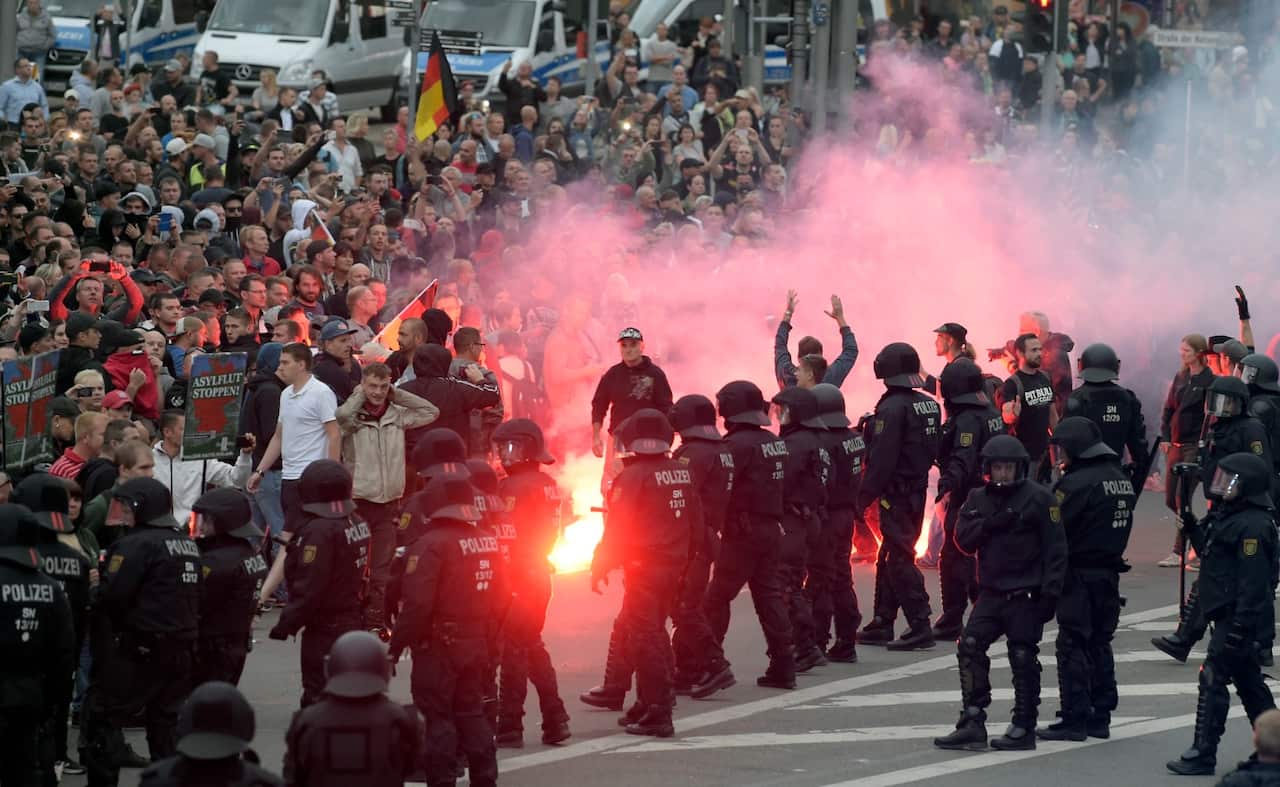 Protesters light fireworks during a far-right demonstration in Chemnitz, Germany, Monday, Aug. 27, 2018