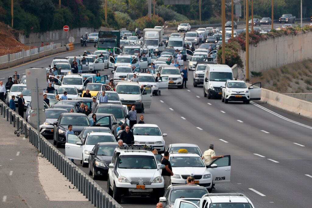 Drivers stop and stand in silence on a highway in the Israeli city of Tel Aviv on April 12, 2017 as sirens wailed across Israel for two minutes.