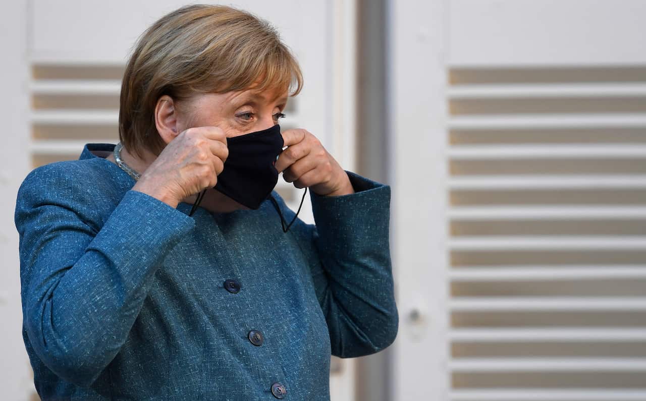 German Chancellor Angela Merkel takes her mask off