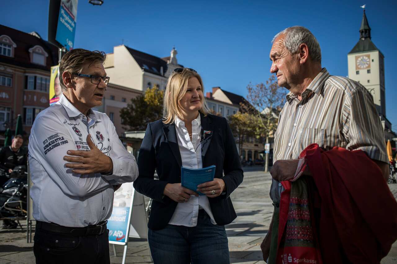 Harold Fischer, left, a retired doctor, talks with Katrin Ebner-Steiner, center, a candidate with the Alternative for Germany party, in Deggendorf, in the Bavarian state of Germany.