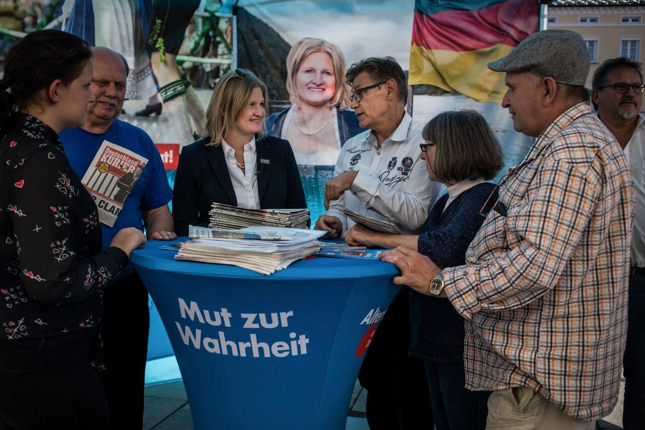 Harold Fischer, center right, a retired doctor, talks with Katrin Ebner-Steiner, center left, a candidate with the Alternative for Germany party, in Deggendorf, in the Bavarian state of Germany.