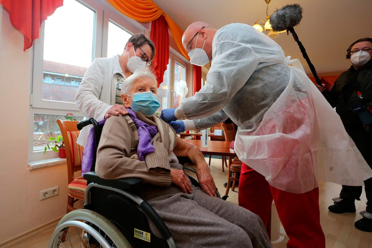 Doctor Bernhard Ellendt, right, injects the COVID-19 vaccine to nursing home resident Edith Kwoizalla, 101 years old, in Halberstadt, Germany.