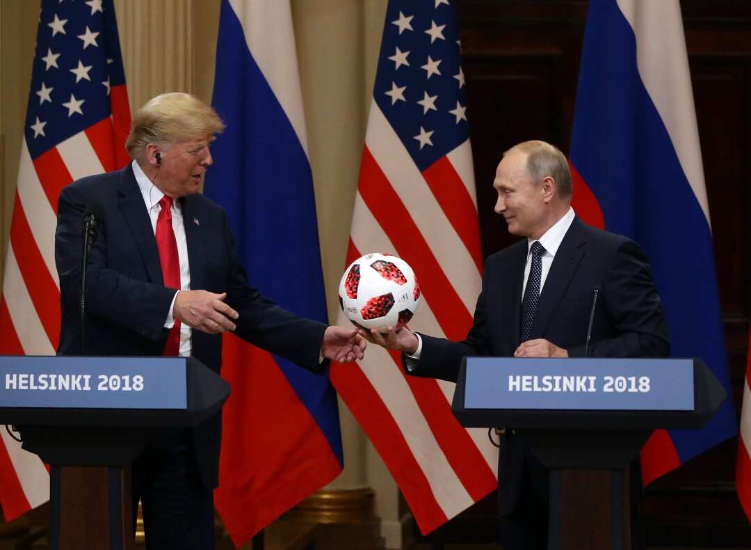 Vladimir Putin gives Donald Trump a soccer ball during the joint press conference.