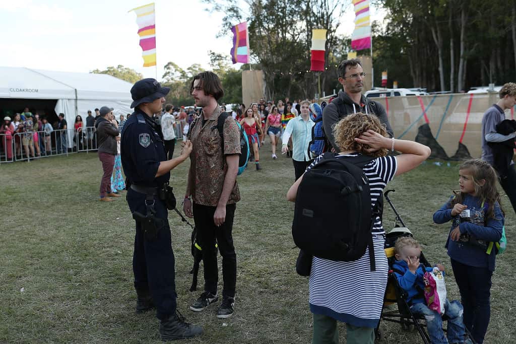 A police officer with a sniffer dog questions a Splendour in the Grass ticket holder in 2018.