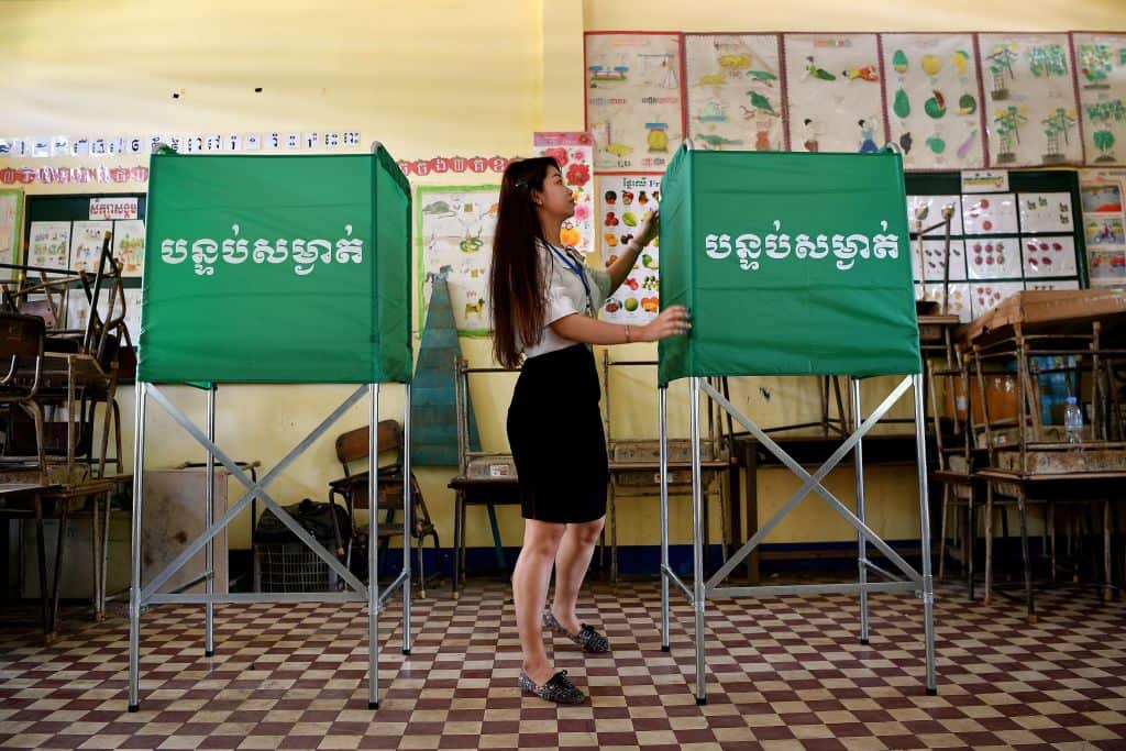 A member of the Cambodian National Election Committee prepares a voting booth in Phnom Penh.